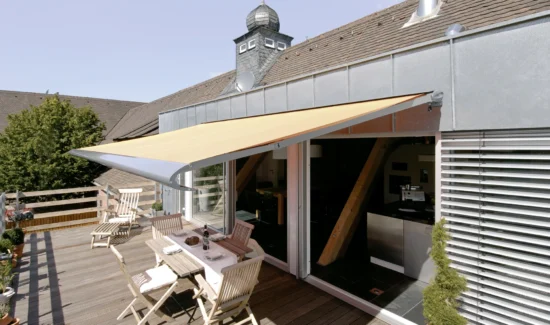 Terrasse mit Markise und Gartenmöbeln an einem sonnigen Tag